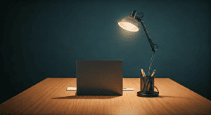 Bureau minimaliste avec ordinateur portable et lampe allumée